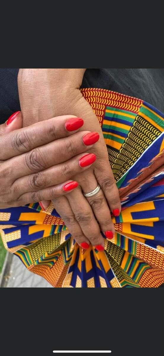 Rote Maniküre auf afrikanischem Stoff